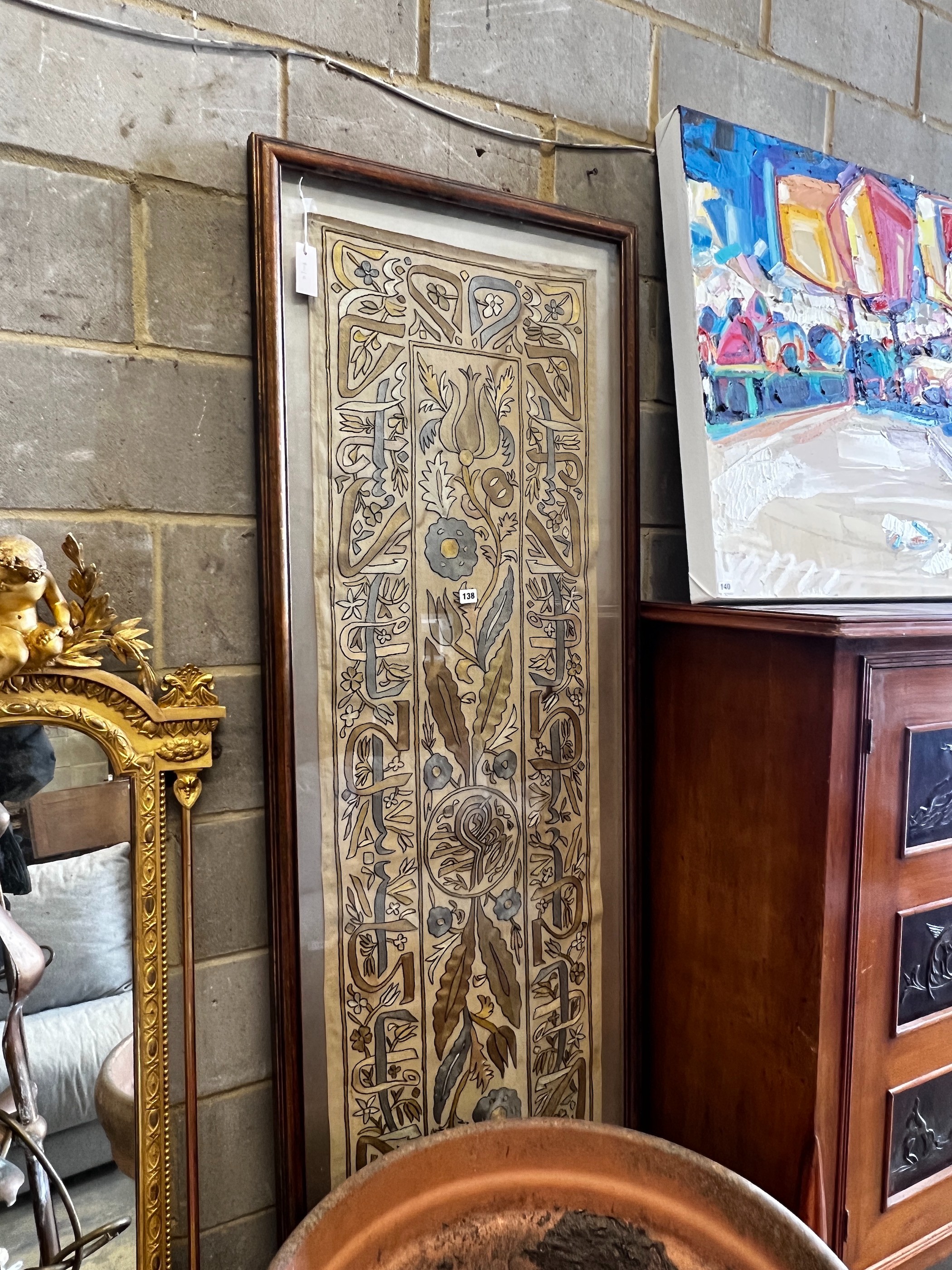 A polychrome embroidered panel, framed, the panel width 51cm, height 192cm